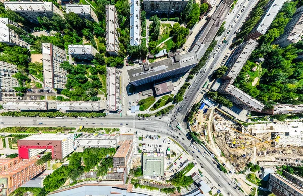 Uitzicht op de stad vanuit de lucht met kruispunten en wegen, huizen, gebouwen, parken en parkeerplaatsen. Zonnige zomer panoramisch beeld — Stockfoto