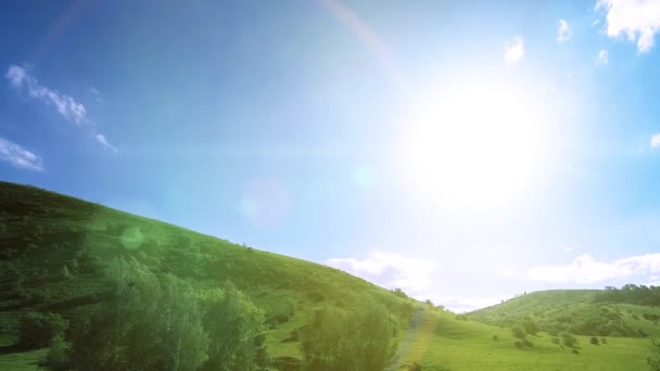 4K UHD prairie de montagne timelapse à l'été. Nuages, arbres, herbe verte et mouvement des rayons du soleil.