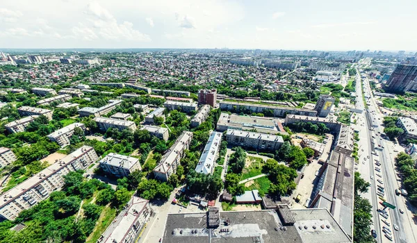 Vista aérea de la ciudad con encrucijadas y caminos, casas, edificios, parques y estacionamientos. Imagen panorámica soleada de verano —  Fotos de Stock