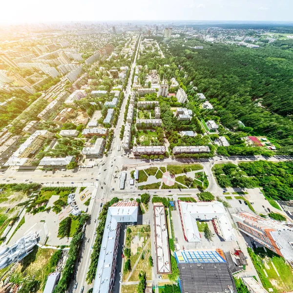 Vista aérea de la ciudad con encrucijadas y caminos, casas, edificios, parques y estacionamientos. Imagen panorámica soleada de verano — Foto de Stock