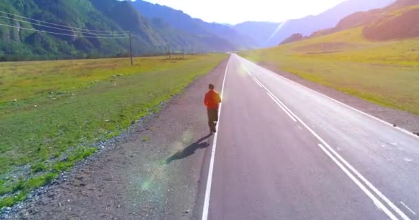 Vuelo de baja altitud frente al deportista en el camino perfecto de asfalto — Vídeo de stock