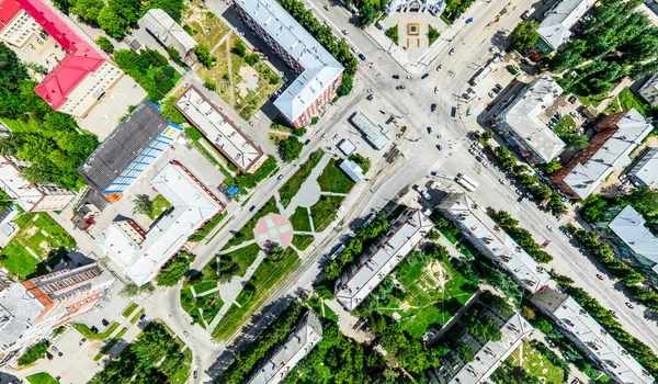 Vista aérea de la ciudad con encrucijadas y caminos, casas, edificios, parques y estacionamientos. Imagen panorámica soleada de verano —  Fotos de Stock