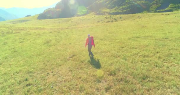 Let nad batohem turistické procházky přes zelené horské pole. Obrovské venkovské údolí v letní den. — Stock video