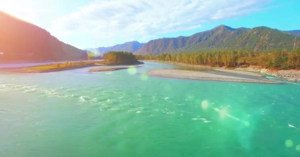 4k UHD vista aérea. Vôo baixo sobre o rio frio fresco da montanha na manhã ensolarada do verão. Árvores verdes e raios solares em horisont — Vídeo de Stock