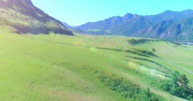 Güneşli yaz sabahında havadan kırsal dağ yolu ve çayır. Asfalt karayolu ve nehir.