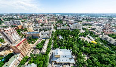 Kesişen yollar, evler, binalar, parklar ve otoparklar olan havacılık şehri manzarası. Güneşli yaz panoramik resmi