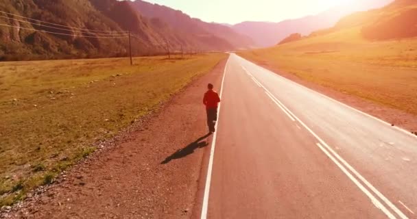 Tiefflug vor sportlichem Mann auf perfekter Asphaltstraße — Stockvideo