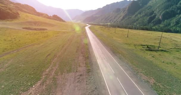 Dağda asfalt karayolu ve çayır üzerinde uçuş — Stok video