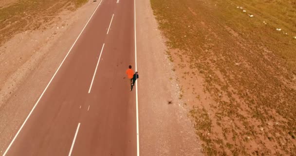 Vuelo de baja altitud sobre el hombre deportivo en la nueva carretera de asfalto — Vídeo de stock