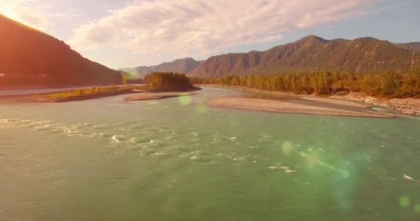 4k UHD hava görüntüsü. Güneşli yaz sabahında taze soğuk dağ nehri üzerinde alçak uçuş. Horisont 'ta yeşil ağaçlar ve güneş ışınları — Stok video