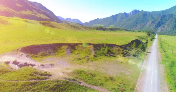 日当たりの良い夏の朝に空中農村部の山岳道路や牧草地。アスファルトハイウェイと川. — ストック動画