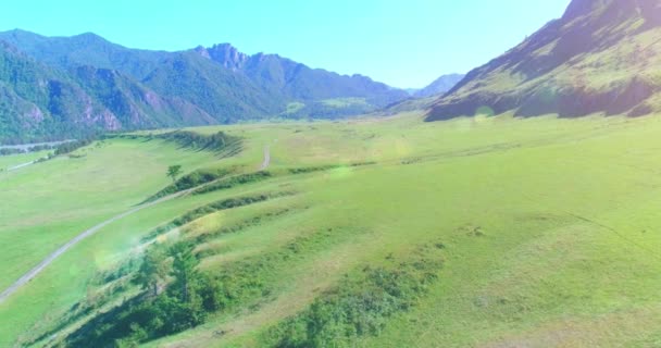 Flyg lantlig bergsväg och äng på solig sommarmorgon. Asfalterad motorväg och flod. — Stockvideo