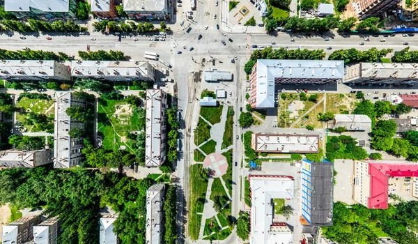 Aerial city view with crossroads and roads, houses, buildings, parks and parking lots. Sunny summer panoramic image — Stock Photo, Image