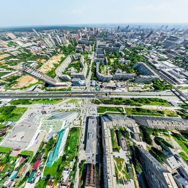 Vista aérea de la ciudad con encrucijadas y caminos, casas, edificios, parques y estacionamientos. Imagen panorámica soleada de verano — Foto de Stock