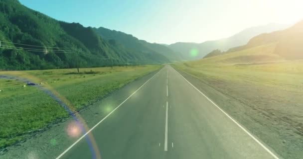夏日阳光明媚的早晨，空中低空飞越山路和草地. — 图库视频影像