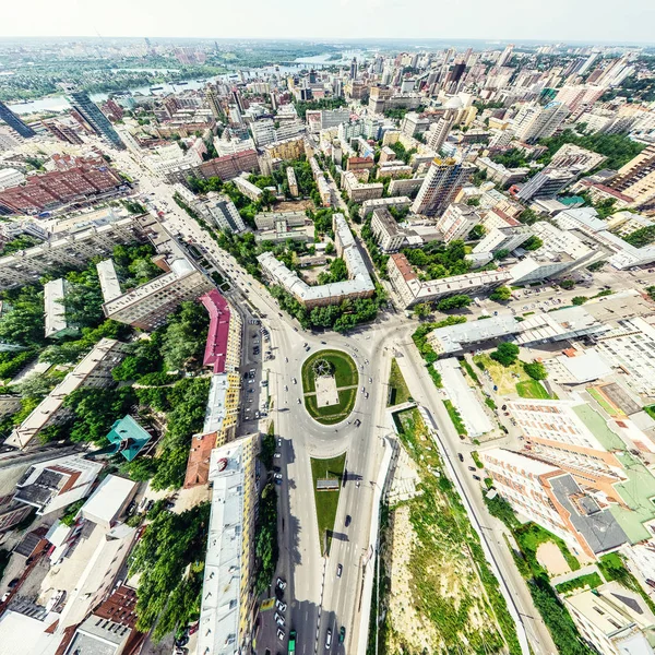 Vista aérea de la ciudad con encrucijadas y caminos, casas, edificios, parques y estacionamientos. Imagen panorámica soleada de verano —  Fotos de Stock