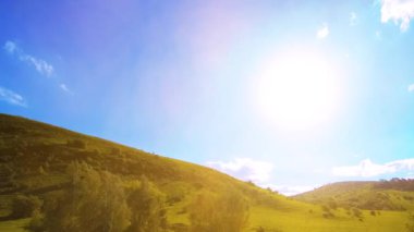 Yazın 4K UHD dağ çayırı zaman dilimi. Bulutlar, ağaçlar, yeşil çimenler ve güneş ışınları hareketi.
