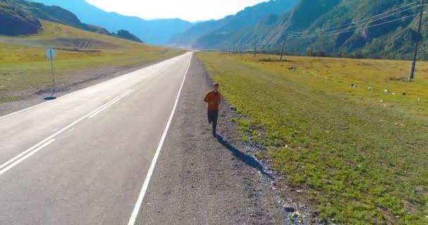 Vuelo de baja altitud frente al deportista en el camino perfecto de asfalto — Vídeos de Stock