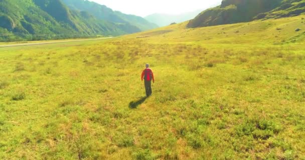 Let nad batohem turistické procházky přes zelené horské pole. Obrovské venkovské údolí v letní den. — Stock video