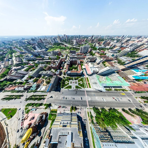 Vista aérea de la ciudad con encrucijadas y caminos, casas, edificios, parques y estacionamientos. Imagen panorámica soleada de verano — Foto de Stock