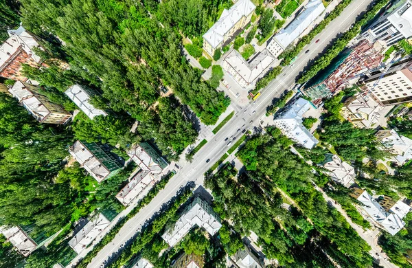 Vista aérea de la ciudad con encrucijadas y caminos, casas, edificios, parques y estacionamientos. Imagen panorámica soleada de verano —  Fotos de Stock