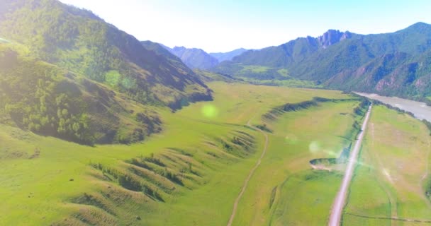 Aerea strada di montagna rurale e prato al sole mattina d'estate. Autostrada asfaltata e fiume. — Video Stock