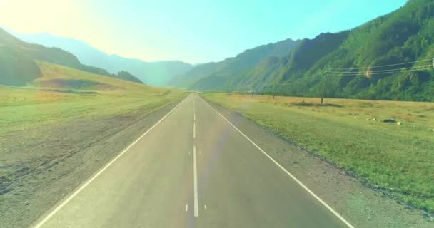 Güneşli yaz sabahında dağ yolu ve çayır üzerinde alçak hava uçuşları.. — Stok video