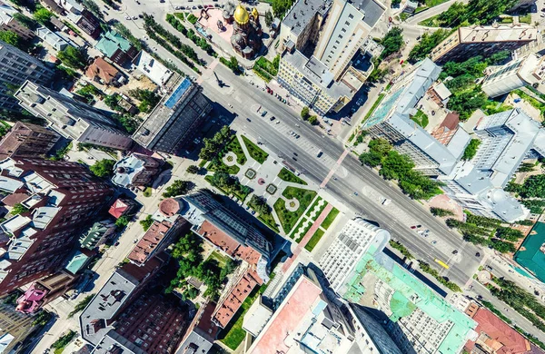 Aerial city view with crossroads and roads, houses, buildings, parks and parking lots. Sunny summer panoramic image — Stock Photo, Image