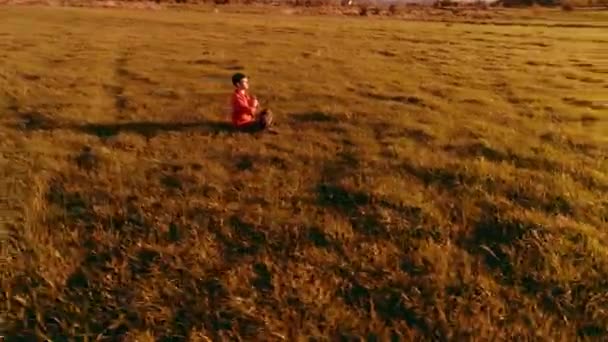 Χαμηλό υψόμετρο ακτινική πτήση πάνω από τον άνθρωπο σπορ γιόγκα σε τέλειο πράσινο γρασίδι. Ηλιοβασίλεμα στο βουνό. — Αρχείο Βίντεο