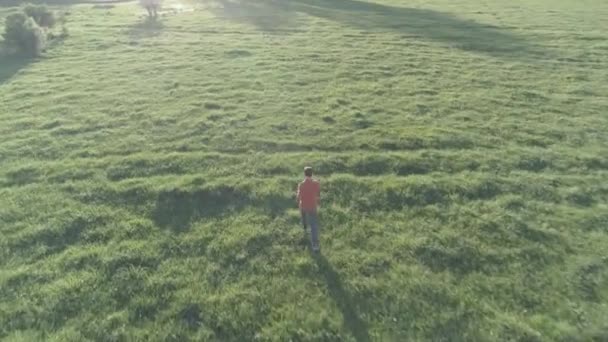 Flyg över sportig man som springer på perfekt grönt gräs landsbygd äng offroad. Solnedgång i berget. Obehandlad platt färg, ingen korrigering. — Stockvideo