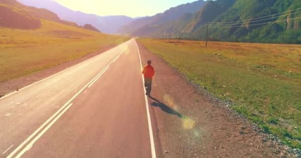 Tiefflug vor sportlichem Mann auf perfekter Asphaltstraße — Stockvideo