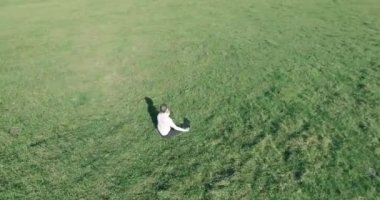 Yeşil çimlerin üzerinde sarı kırsal alanda not defteri olan bir adamın etrafında alçak yörünge uçuşları..