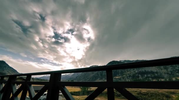 Timelapse van houten hek op hoog terras bij berglandschap met wolken. Horizontale schuifbeweging — Stockvideo