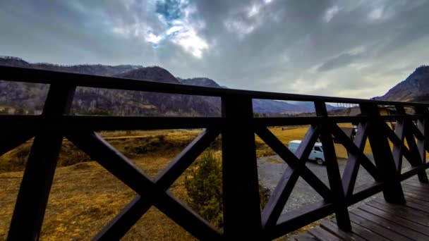 Timelapse του ξύλινου φράχτη στην ψηλή βεράντα στο ορεινό τοπίο με σύννεφα. Οριζόντια κίνηση κύλισης — Αρχείο Βίντεο