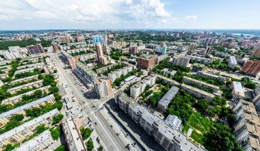 Kesişen yollar, evler, binalar, parklar ve otoparklar olan havacılık şehri manzarası. Güneşli yaz panoramik resmi