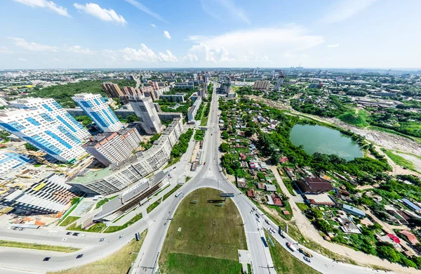 Vedere aeriană a orașului cu răscruce de drumuri și drumuri, case, clădiri, parcuri și locuri de parcare. Imagine panoramică de vară însorită — Fotografie, imagine de stoc