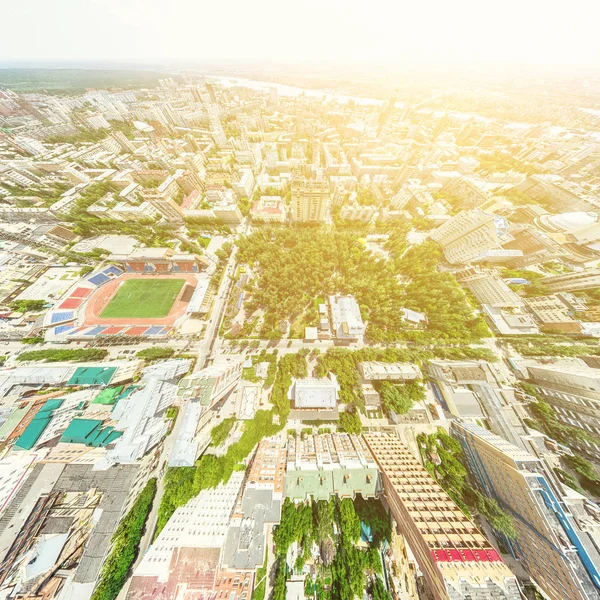 Vista aérea de la ciudad con encrucijadas y caminos, casas, edificios, parques y estacionamientos. Imagen panorámica soleada de verano — Foto de Stock