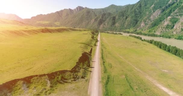 Route de montagne rurale aérienne et prairie au matin ensoleillé d'été. Asphalte autoroute et rivière.