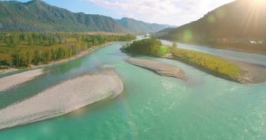 Güneşli yaz sabahında kayalarla birlikte taze, hızlı dağ nehri üzerinde alçak irtifa uçuşu..