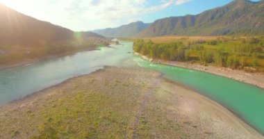 Güneşli yaz sabahında kayalarla birlikte taze, hızlı dağ nehri üzerinde alçak irtifa uçuşu..