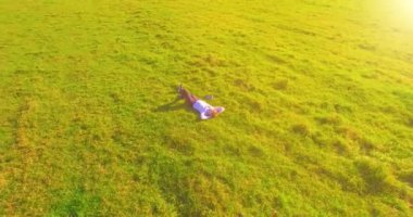 Yeşil çimlerin üzerinde sarı kırsal alanda not defteri olan bir adamın etrafında alçak yörünge uçuşları..