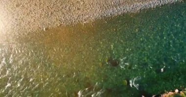 Güneşli yaz sabahında kayalarla birlikte taze, hızlı dağ nehri üzerinde alçak irtifa uçuşu..