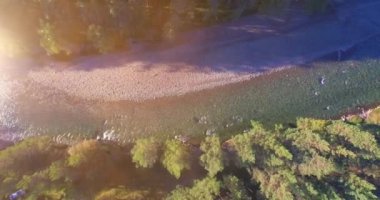 Güneşli yaz sabahında kayalarla birlikte taze, hızlı dağ nehri üzerinde alçak irtifa uçuşu..