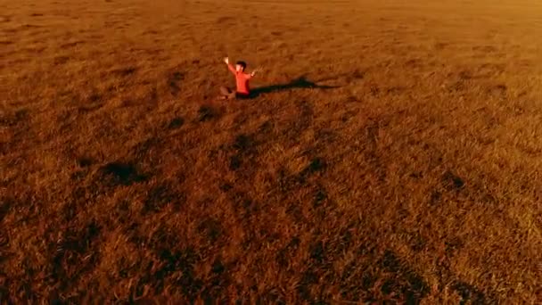 Vuelo radial de baja altitud sobre el hombre del yoga del deporte en hierba verde perfecta. Puesta de sol en montaña. — Vídeos de Stock