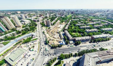 Kesişen yollar, evler, binalar, parklar ve otoparklar olan havacılık şehri manzarası. Güneşli yaz panoramik resmi