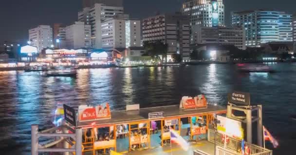 Timelapse del puerto de Maharaj y la zona del ferry en el río Chao Phraya. Iluminación nocturna en Bangkok, Asia, Tailandia, 22 NOV 2018 — Vídeos de Stock
