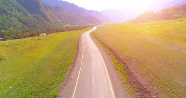 Dağda asfalt karayolu ve çayır üzerinde uçuş