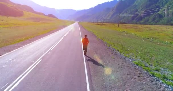 Низкая высота полета перед спортивным человеком на идеальной асфальтовой дороге — стоковое видео