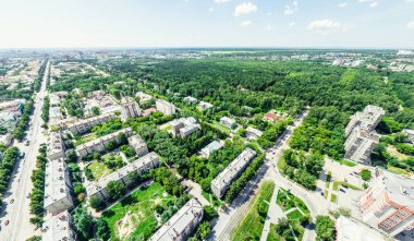 Kesişen yollar, evler, binalar, parklar ve otoparklar olan havacılık şehri manzarası. Güneşli yaz panoramik resmi