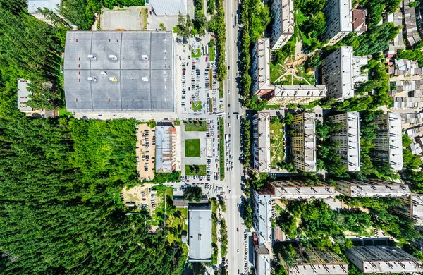 Vista aérea de la ciudad con encrucijadas y caminos, casas, edificios, parques y estacionamientos. Imagen panorámica soleada de verano —  Fotos de Stock